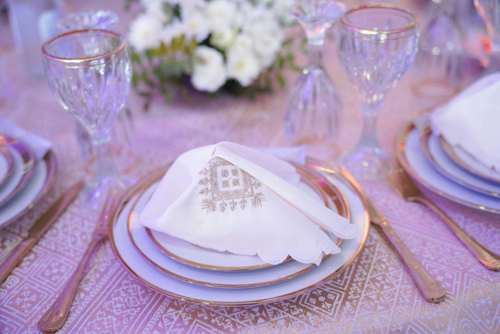 Elegancko udekorowana sala bankietowa na przyjęcie okolicznościowe – jasne wnętrze z okrągłymi stołami, białymi obrusami i kwiatowymi dekoracjami